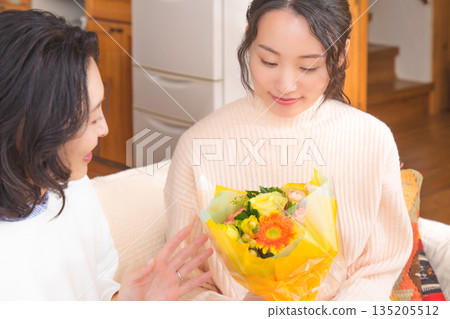 Daughter giving a present to her mother Daughter giving a present to her mother 135205512