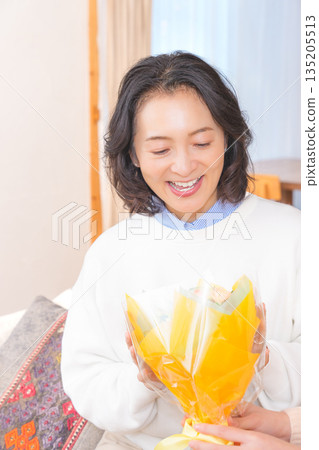 Daughter giving a present to her mother Daughter giving a present to her mother 135205513