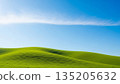 Vast green hills meet clear blue sky with thin cloud, symbolizing tranquility and natural beauty for spring and summer background. 135205632