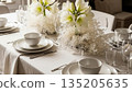 Elegant table setting with white amaryllis flowers and tableware, creating a festive atmosphere for a Christmas or holiday dinner arrangement. 135205635
