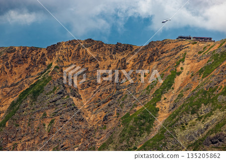 A mountain hut and a helicopter unloading cargo seen from Mount Amida in the Yatsugatake Mountain Range 135205862