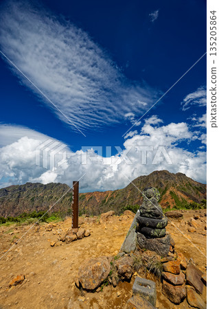 A stone Buddha statue on the summit of Mount Amida in the Yatsugatake mountain range, and a view of Mount Aka and Mount Yoko A stone Buddha statue on the summit of Mount Amida in the Yatsugatake mountain range, and a view of Mount Aka and Mount Yoko 135205864