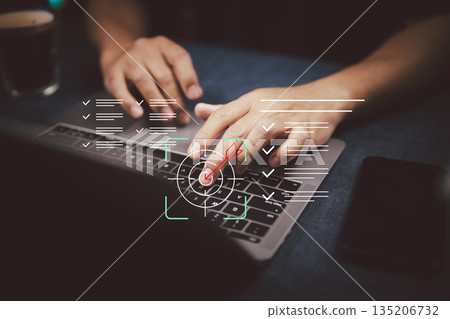 Hands typing on laptop keyboard with digital checklist and target graphics 135206732