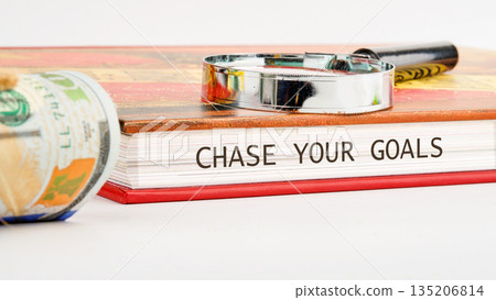 Rolled USD, open book CHASE YOUR GOALS, magnifying glass. Seek knowledge wealth Rolled USD, open book CHASE YOUR GOALS, magnifying glass. Seek knowledge wealth 135206814