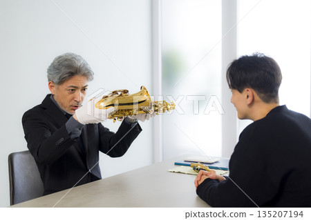 A man appraising a saxophone A man appraising a saxophone 135207194