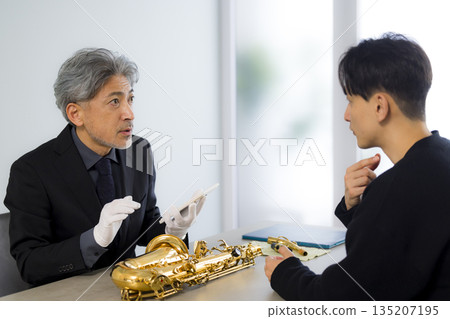 A man appraising a saxophone 135207195