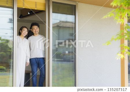 一對中年夫妻站在窗邊 135207317