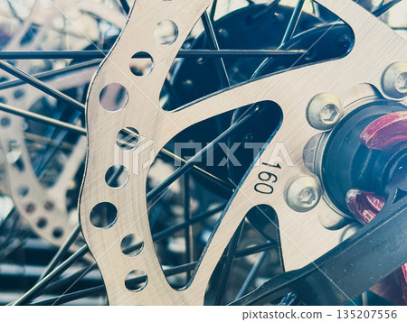 Close-up of a bicycle disc brake rotor and wheel. Close-up of a bicycle disc brake rotor and wheel. 135207556