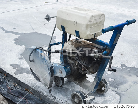 Concrete saw on pavement at a construction site. Concrete saw on pavement at a construction site. 135207586