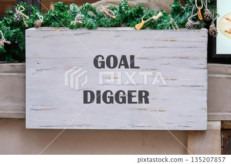 GOAL DIGGER sign: white wood, bold text, evergreen garland pinecones GOAL DIGGER sign: white wood, bold text, evergreen garland pinecones 135207857