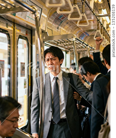 通勤列車上，一位看起來很疲憊的商人 135208139