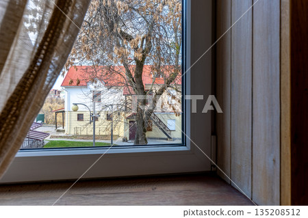 View from the window of a rustic house to a cozy courtyard View from the window of a rustic house to a cozy courtyard 135208512