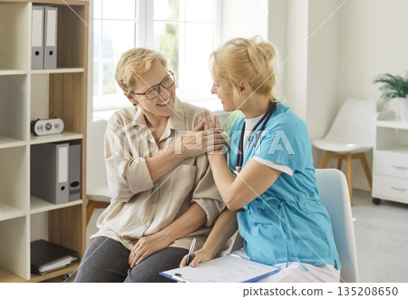 Smiling nurse supporting senior patient during friendly medical consultation 135208650