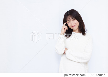 Woman thinking with a smile Woman thinking with a smile 135209044