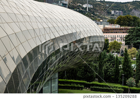 Modern Architecture Of The Bridge Of Peace And Glass Structures In Central Tbilisi Georgia: Contemporary Design Amidst Greenery And Historic Urban Landscape Modern Architecture Of The Bridge Of Peace And Glass Structures In Central Tbilisi Georgia: Contemporary Design Amidst Greenery And Historic Urban Landscape 135209288