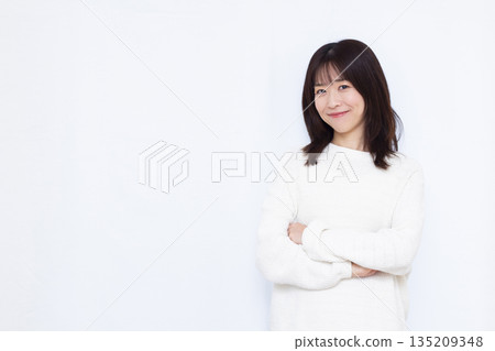 A woman thinking with her arms folded 135209348