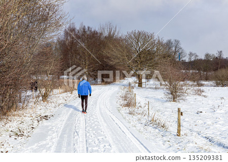 Winter outdoor run with healthy male walking in park. 135209381