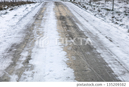 Winter road with icy tracks and car hazard. Winter road with icy tracks and car hazard. 135209382