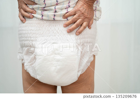 Asian senior woman patient wearing adult incontinence diaper pad in hospital. 135209676