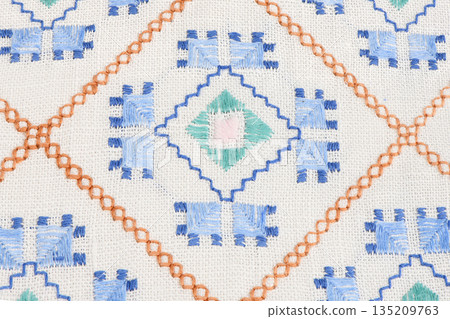 Geometric ethnic embroidery pattern on white linen texture 135209763