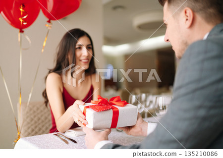 Valentine's Day concept. Happy couple in love. Couple celebrating Valentine's Day in restaurant. 135210086