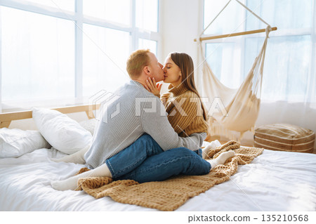Couple in love relaxing at home on bed while they hug each other. Valentine's Day, holiday concept. 135210568