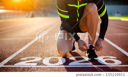 Runner Preparing for Race in Sunset Light on Athletic Track 2026 135210911