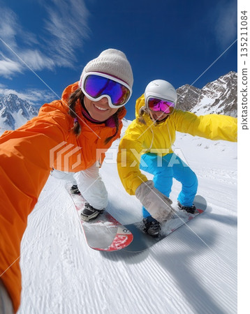 Two Friends Enjoying Snowboarding on a Sunny Day 135211084