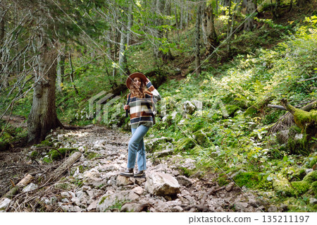 Woman with backpack hiking outdoors in the Forest. Trekking in the Pine Woods. Hiking lifestyle 135211197