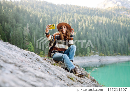 Happy tourist woman taking picture outdoors for memories. Selfie time. Lifestyle, active life. Happy tourist woman taking picture outdoors for memories. Selfie time. Lifestyle, active life. 135211207