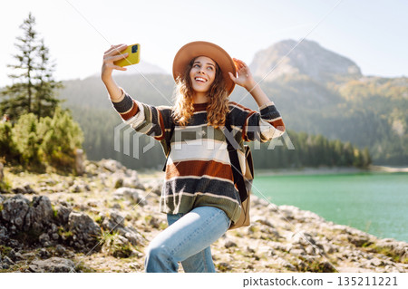 Happy tourist woman taking picture outdoors for memories. Selfie time. Lifestyle, active life. Happy tourist woman taking picture outdoors for memories. Selfie time. Lifestyle, active life. 135211221