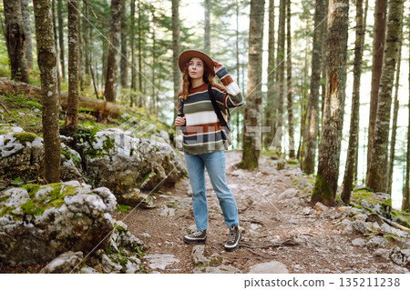 Woman with backpack hiking outdoors in the Forest. Trekking in the Pine Woods. Hiking lifestyle 135211238