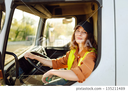 Portrait of beautiful young woman professional truck driver checking shipment list on a -parking lot 135211489