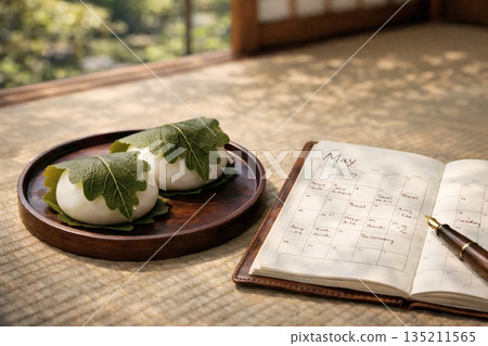 走廊榻榻米上擺放著柏餅，旁邊還有一本寫著五月行程的筆記本。 135211565