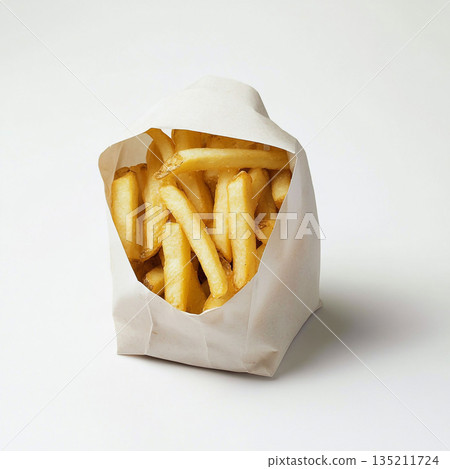 A brown paper bag filled with golden, crispy French fries is shown against a white background. 135211724