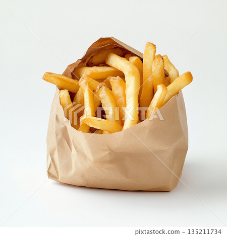 A brown paper bag filled with golden, crispy French fries is shown against a white background. 135211734