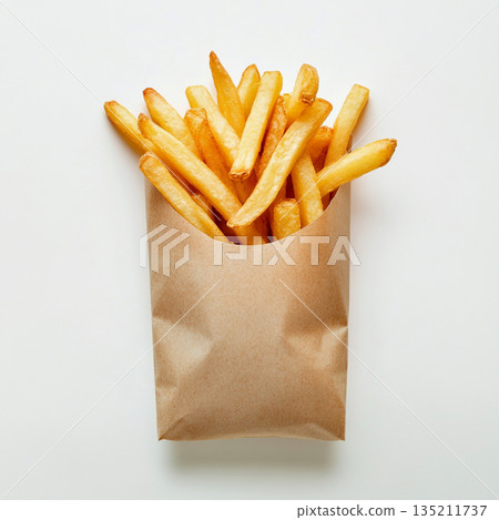A brown paper bag filled with golden, crispy French fries is shown against a white background. A brown paper bag filled with golden, crispy French fries is shown against a white background. 135211737