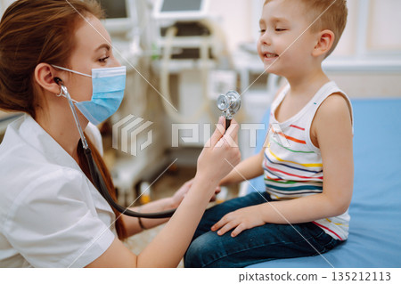 Female Doctor examining a little boy by stethoscope. ?hild's health Female Doctor examining a little boy by stethoscope. ?hild's health 135212113