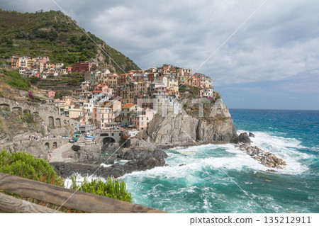 Colorful houses of a coastal town built on steep rocky cliffs above the sea. Popular travel destination and Mediterranean landscape 135212911