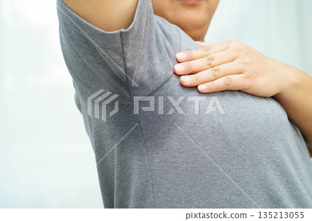 Sweaty underarms, Asian woman with sweat on clothes under armpit. 135213055