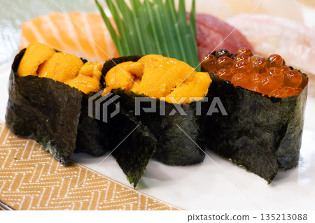 Delicious Hokkaido nigiri sushi including gunkanmaki rolls with sea urchin and salmon roe 135213088