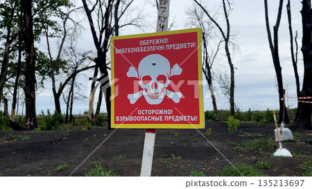 Warning sign that says Beware, explosive objects. Warning signs near mined areas Warning sign that says Beware, explosive objects. Warning signs near mined areas 135213697
