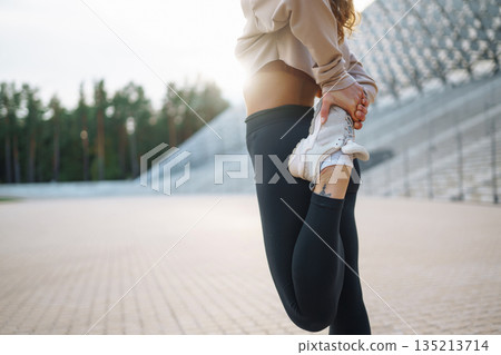 Young woman in sportswear is training outdoors. Sports concept, healthy body. 135213714