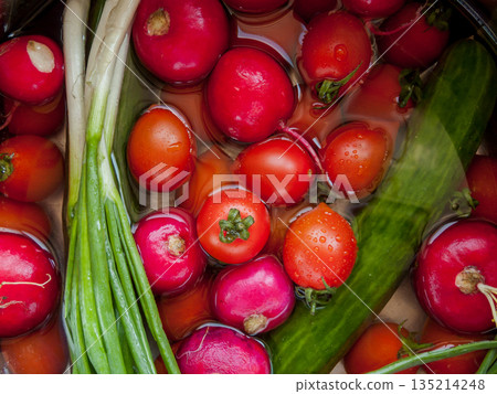 Bunch of fresh vegetables rinsed in the bowl with water in the sink, close up of veggies in the bowl covered with water drops. Bunch of fresh vegetables rinsed in the bowl with water in the sink, close up of veggies in the bowl covered with water drops. 135214248