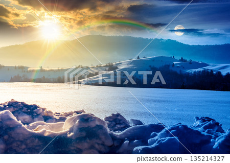 beautiful winter landscape with snow covered rolling hills. day and night time change concept. majestic mountains with sun and moon. frosty countryside scenery. harmony and progress calendar 135214327