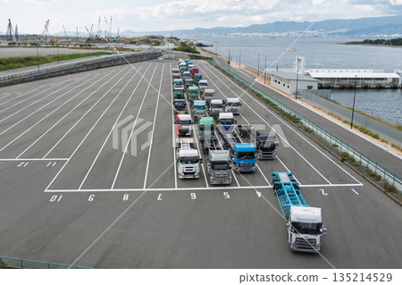 在大阪夢島貨櫃碼頭,拖車整齊地排列著,遠處可以看到規劃中的綜合體建設工地(物流/2024 年問題)。 在大阪夢島貨櫃碼頭,拖車整齊地排列著,遠處可以看到規劃中的綜合體建設工地(物流/2024 年問題)。 135214529