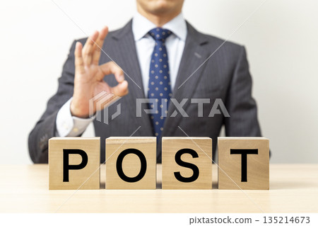 A businessman making an OK pose with a block that says "POST" A businessman making an OK pose with a block that says "POST" 135214673