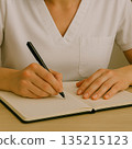 一位從事護理工作的女性在筆記本上做筆記。 135215123