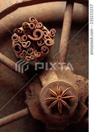 Cinnamon sticks and anise on a rusty background. 135215257