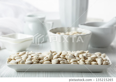 Dried white beans on a white table. Dried white beans on a white table. 135215265